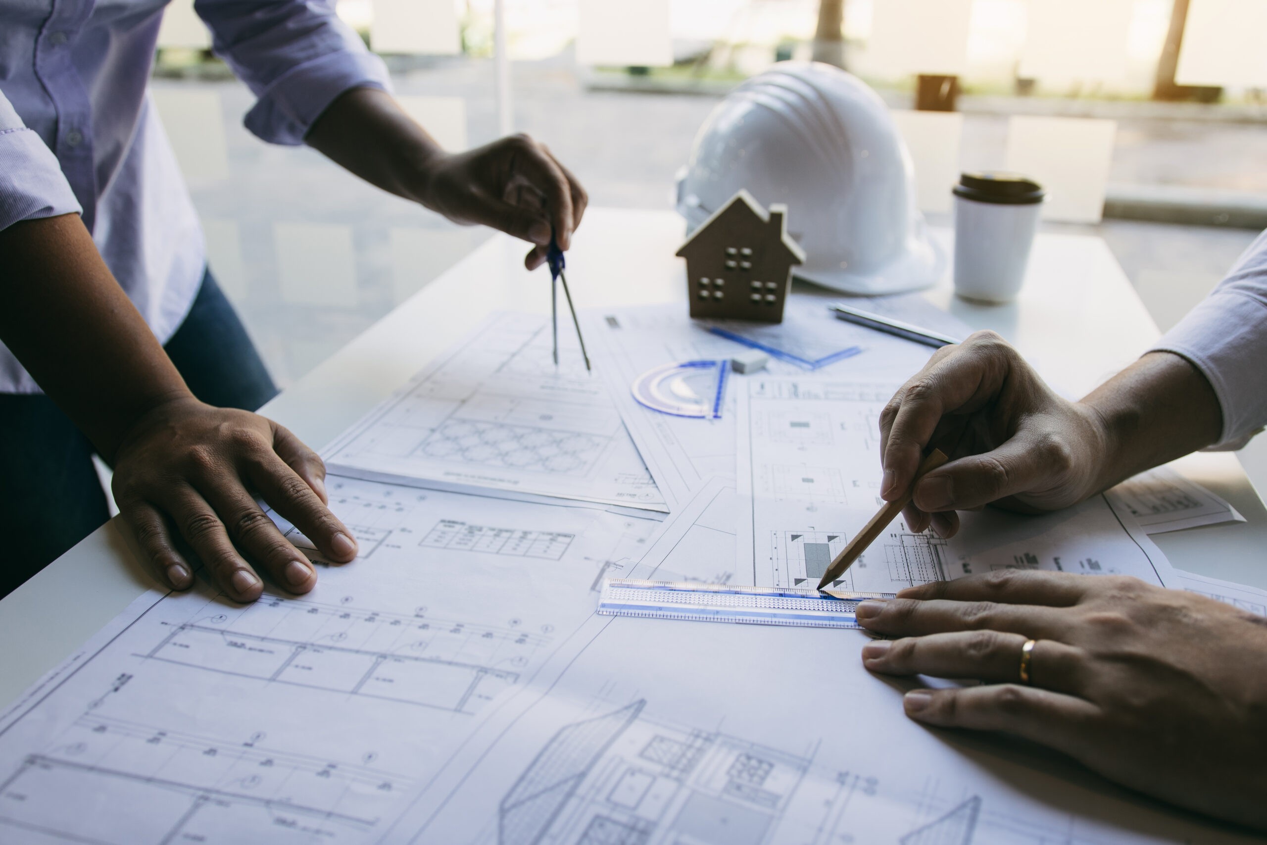 Team architect or engineering people discussion working on table together at a construction site.